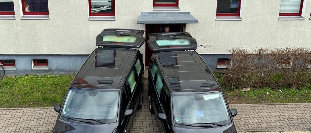 Zwei Leichenwagen stehen am Eingang zu einem Haus. 