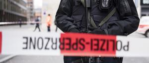 Ein schwer bewaffneter Polizist steht hinter einem Absperrband in der Züricher Innenstadt. 