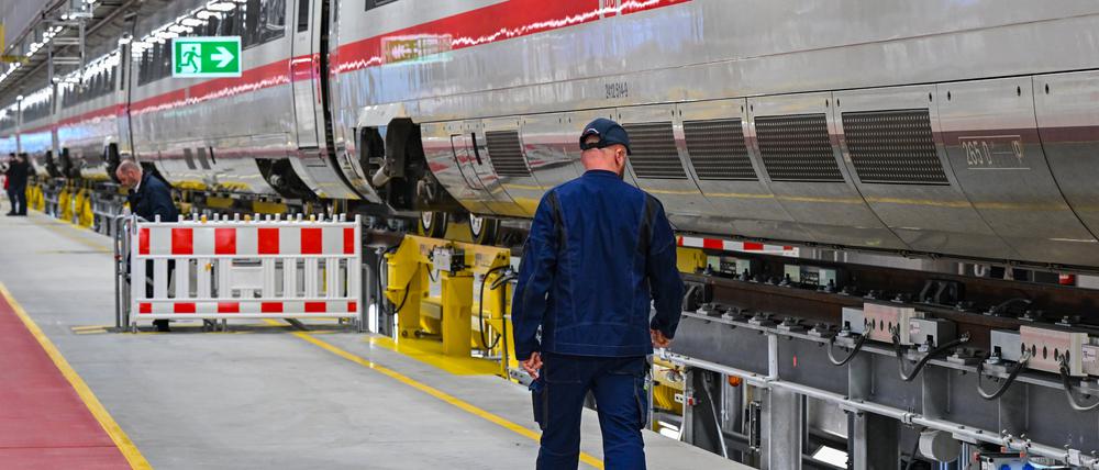 Ein Mitarbeiter der Deutschen Bahn geht an einem ICE des DB-Instandhaltungswerks für ICE 4-Züge vorbei.