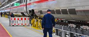 Ein Mitarbeiter der Deutschen Bahn geht an einem ICE des DB-Instandhaltungswerks für ICE 4-Züge vorbei. 