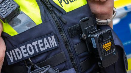 Eine neue Body-Cam hängt an der Schutzweste einer Polizeibeamtin. (Archivbild)