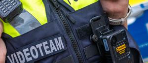 Eine neue Body-Cam hängt an der Schutzweste einer Polizeibeamtin. (Archivbild)