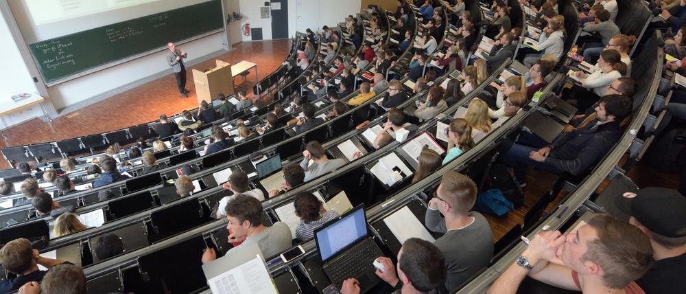 In einem großen Hörsaal der Universität Ulm nehmen Studierende an einer Vorlesung teil. 