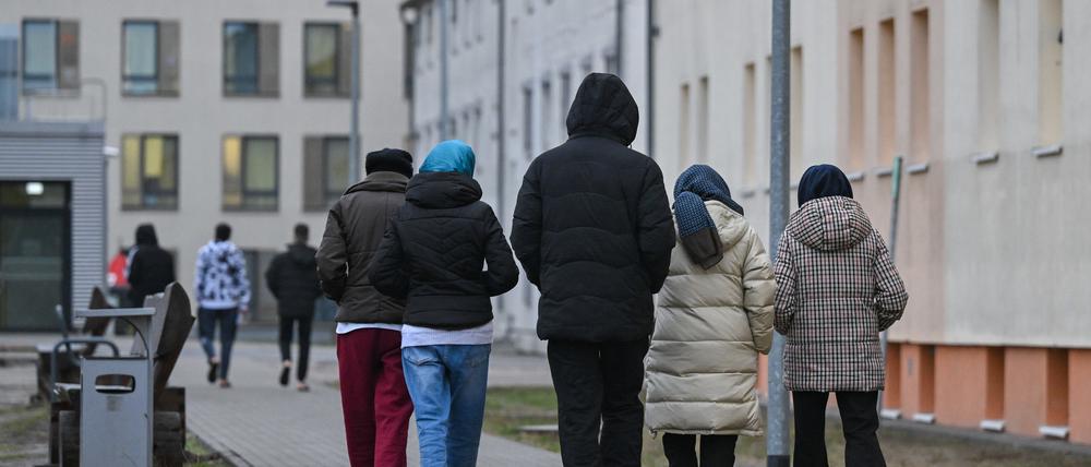 Migranten gehen über das Gelände der Zentralen Erstaufnahmeeinrichtung für Asylbewerber (ZABH) des Landes Brandenburg in Eisenhüttenstadt.