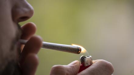 Ein Mann zündet sich einen Joint an.