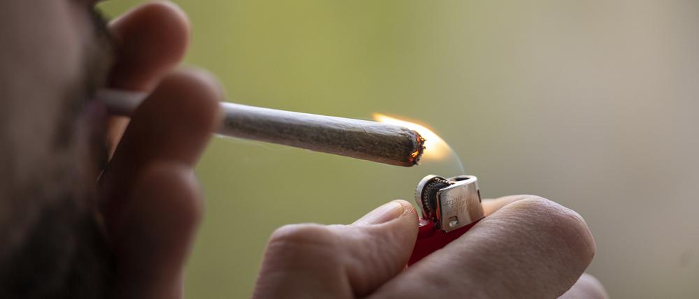 Ein Mann zündet sich einen Joint an.