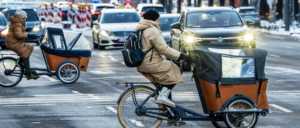 Frauen mit Lastenfahrrädern überqueren die Prinzregentenstraße, München im Januar 2024.