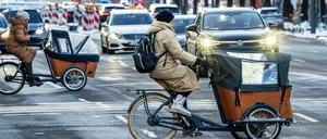 Frauen mit Lastenfahrrädern überqueren die Prinzregentenstraße, München im Januar 2024.
