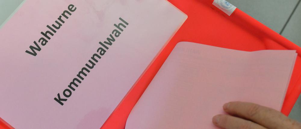 Eine Wählerin steckt ihren Stimmzettel zur Kommunalwahl in Brandenburg in die Wahlurne. (Archivbild 2019)