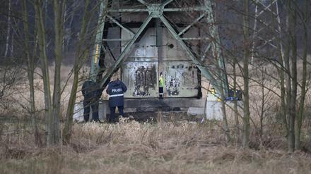 Polizei ermittelt an einem beschädigten Strommasten auf einem Feld bei Spreenhagen. 