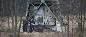 Polizei ermittelt an einem beschädigten Strommasten auf einem Feld bei Spreenhagen. 
