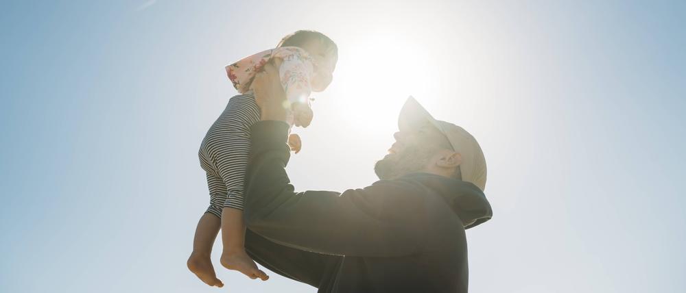 Father holding up baby girl at backlight model released Symbolfoto PUBLICATIONxINxGERxSUIxAUTxHUNxONLY GEMF02034