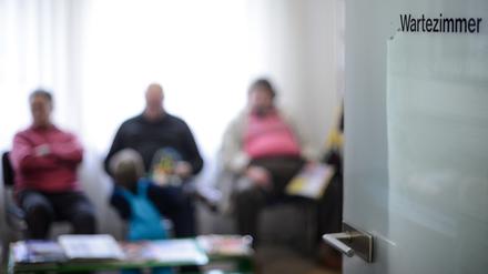 Patienten warten im Wartezimmer einer Arztpraxis.