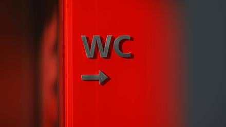 Ein Schild weist auf ein WC in einem Theater hin.