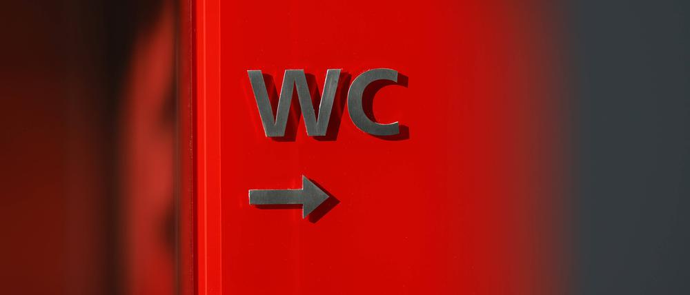 Ein Schild weist auf ein WC in einem Theater hin.