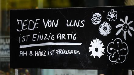 Jede von ist einzigartig - Am 8. März ist Frauentag· steht auf einem Schild vor einem Blumenladen.