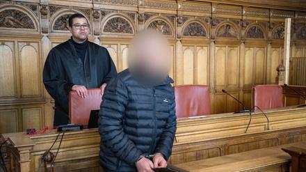 Der Angeklagte steht vor Prozessbeginn mit seinem Anwalt Temba Hoch im Gerichtssaal.