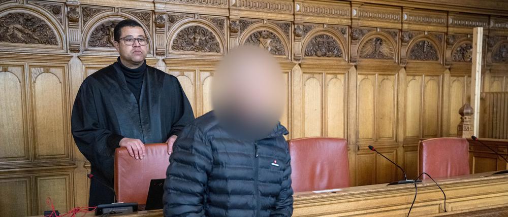 Der Angeklagte steht vor Prozessbeginn mit seinem Anwalt Temba Hoch im Gerichtssaal.