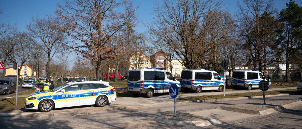 Polizeiautos stehen vor einer Schule. In der Schule wurde ein 22 Jahre alter Mann festgenommen, der ein Messer und eine Schusswaffe bei sich gehabt hat.