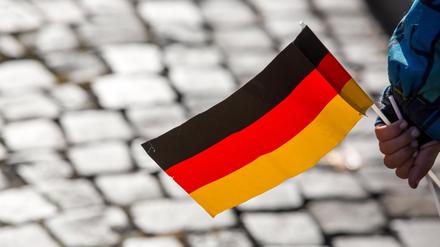  Ein Kind hält am 09.11.2014 an der früheren Grenze zwischen Vacha (Thüringen) und Philippsthal (Hessen) am Jahrestag des Mauerfalls vor 25 Jahren eine Deutschlandflagge. 