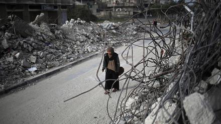 Eine Palästinenserin geht am 3. März 2024 in Rafah im südlichen Gazastreifen an den Trümmern von Häusern vorbei. 