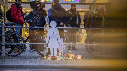 Weiße Silhouetten einer Frau und eines Kindes stehen bei einer Mahnwache an der Leipziger Straße. 