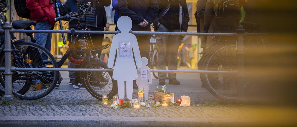 Weiße Silhouetten einer Frau und eines Kindes stehen bei einer Mahnwache an der Leipziger Straße.