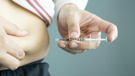 Ein Diabetes-Patient injiziert Insulin im Bauchbereich.