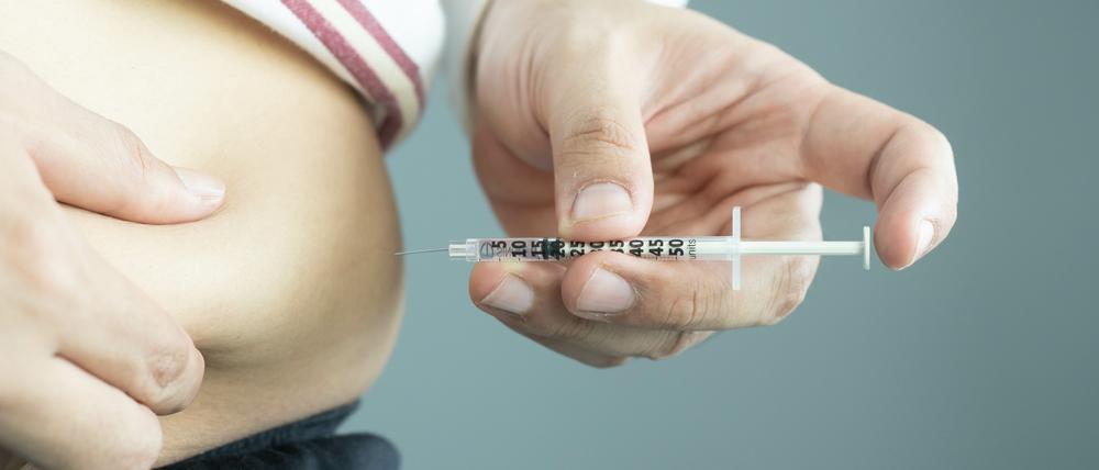 Ein Diabetes-Patient injiziert Insulin im Bauchbereich.