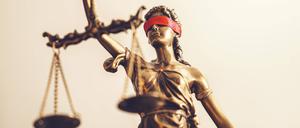 Symbolbild einer Justitia mit verbundenen Augen und einer Waage.