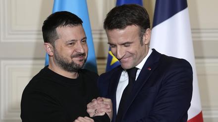 Wolodymyr Selenskyj (l), Präsident der Ukraine, und Emmanuel Macron, Präsident von Frankreich, geben sich nach einer Pressekonferenz im Elysee-Palast die Hand. 