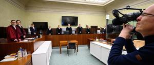 Die Vertreter der Anklage stehen zusammen mit Detlev Schmidt (M), Vorsitzender Richter am Kammergericht, und anderen Richtern und Gerichtsmitarbeitern vor Beginn des Prozesses wegen des Vorwurfs des Landesverrats an einen Mitarbeiter des Bundesnachrichtendienstes (BND) und dessen mutmaßlichen Mittäter im Gerichtssaal vom 6. Strafsenat des Kammergerichts Berlin.