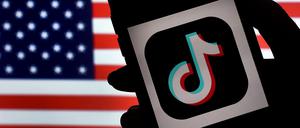 Eine Fotoillustration, die die Flage der USA und das TikTok-Logo auf einem Handy zeigt.
