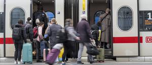 Reisende steigen am Dienstag in München in einen der wenigen verkehrenden Fernzüge.