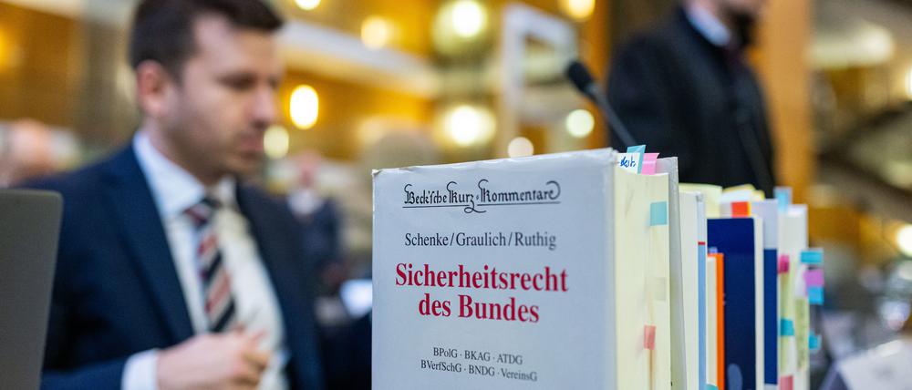 13.03.2024, Nordrhein-Westfalen, Münster: Bei der Fortsetzung im Berufungsverfahren um den Streit der Einstufung der AfD durch den Verfassungsschutz steht unter anderem ein Buch über Sicherheitsrecht des Bundes auf dem Tisch der Anwälte der AfD, Michael Fengler (l) und Christian Conrad.  