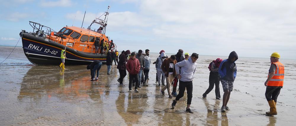 Eine Gruppe von Menschen, bei denen es sich vermutlich um Migranten handelt, wird von einem Rettungsboot nach einem Zwischenfall mit einem kleinen Boot im Ärmelkanal an Land gebracht.