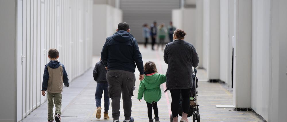 Eine Flüchtlingsfamilie geht durch die zu einer Massenunterkunft umfunktionierten Messehalle in Frankfurt. In der Halle sind seit einigen Wochen mehrere hundert Migranten und Asylsuchende aus unterschiedlichen Herkunftsländern untergebracht. 