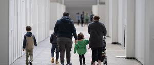 Eine Flüchtlingsfamilie geht durch die zu einer Massenunterkunft umfunktionierten Messehalle in Frankfurt. In der Halle sind seit einigen Wochen mehrere hundert Migranten und Asylsuchende aus unterschiedlichen Herkunftsländern untergebracht. 