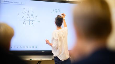 ARCHIV - 17.08.2023, Niedersachsen, Hannover: Eine Lehrerin schreibt eine Mathematikaufgabe auf eine digitale Schultafel im Klassenraum einer 4. Klasse einer Grundschule in der Region Hannover. (zu dpa: «Gericht bestätigt Vorgriffsstunde für Lehrer in Sachsen-Anhalt») Foto: Julian Stratenschulte/dpa +++ dpa-Bildfunk +++