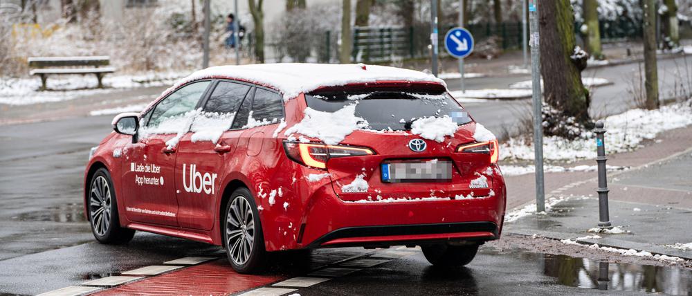 Ein Mietwagenauto auf den Straßen von Berlin. Das Fahrzeug gehört nicht Uber, der Konzern hat nur Werbung darauf geklebt.