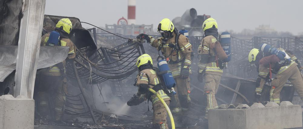12.03.2024, Berlin: Die Feuerwehr löscht die Brandstelle bei Flüchtlingsunterkunft am ehemaligen Flughafen Tegel. Die Berliner Feuerwehr ist zu einem Großeinsatz zur Flüchtlingsunterkunft am früheren Flughafen Tegel ausgerückt. Foto: Carsten Koall/dpa +++ dpa-Bildfunk +++
