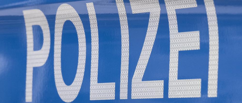 Der Schriftzug Polizei ist auf einem Streifenwagen zu lesen.