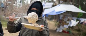 dpatopbilder - 17.03.2024, Brandenburg, Grünheide: Ein Aktivist nimmt sich in einem Camp der Initiative «Tesla stoppen» in einem Kiefernwald nahe der Tesla-Gigafactory Berlin-Brandenburg eine Portion Porridge. Ziel der Aktivisten ist es, eine Rodung des Waldstücks im Zuge einer geplanten Erweiterung des Tesla-Geländes mit Güterbahnhof zu verhindern. Foto: Sebastian Christoph Gollnow/dpa +++ dpa-Bildfunk +++