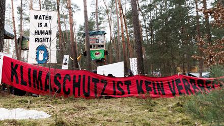 16.03.2024, Brandenburg, Grünheide: Transparente mit den Texten «Klimaschutz ist kein Verbrechen» und «Water is a human right» hängen in einem Camp der Initiative «Tesla stoppen» in einem Kiefernwald nahe der Tesla-Gigafactory Berlin-Brandenburg. Ziel der Aktivisten ist es, eine Rodung des Waldstücks im Zuge einer geplanten Erweiterung des Tesla-Geländes mit Güterbahnhof zu verhindern. Foto: Carsten Koall/dpa +++ dpa-Bildfunk +++