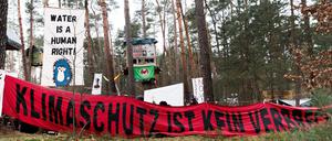 16.03.2024, Brandenburg, Grünheide: Transparente mit den Texten «Klimaschutz ist kein Verbrechen» und «Water is a human right» hängen in einem Camp der Initiative «Tesla stoppen» in einem Kiefernwald nahe der Tesla-Gigafactory Berlin-Brandenburg. Ziel der Aktivisten ist es, eine Rodung des Waldstücks im Zuge einer geplanten Erweiterung des Tesla-Geländes mit Güterbahnhof zu verhindern. Foto: Carsten Koall/dpa +++ dpa-Bildfunk +++