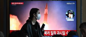 Eine Frau passiert im südkoreanischen Seoul einen Monitor, der Bilder eines nordkoreanischen Raketentests zeigt.