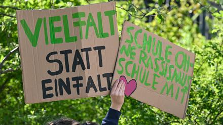 ARCHIV - 09.05.2023, Brandenburg, Cottbus: Teilnehmer der Demonstration «Vielfalt statt Einfalt - Schule ohne Diskriminierung» stehen mit Plakaten vor dem Schulamt in Cottbus. Organisiert wurde die Demonstration von Schülern, Eltern und Lehrern. Am Dienstag wollen Menschen erneut auf die Straße gehen. Kürzlich wurde bekannt, dass ein Lehrer zwei Schüler mit Migrationshintergrund angegriffen haben soll. (zu dpa: «Demo vor Cottbuser Schulamt nach Lehrer-Angriff auf zwei Schüler») Foto: Patrick Pleul/dpa +++ dpa-Bildfunk +++