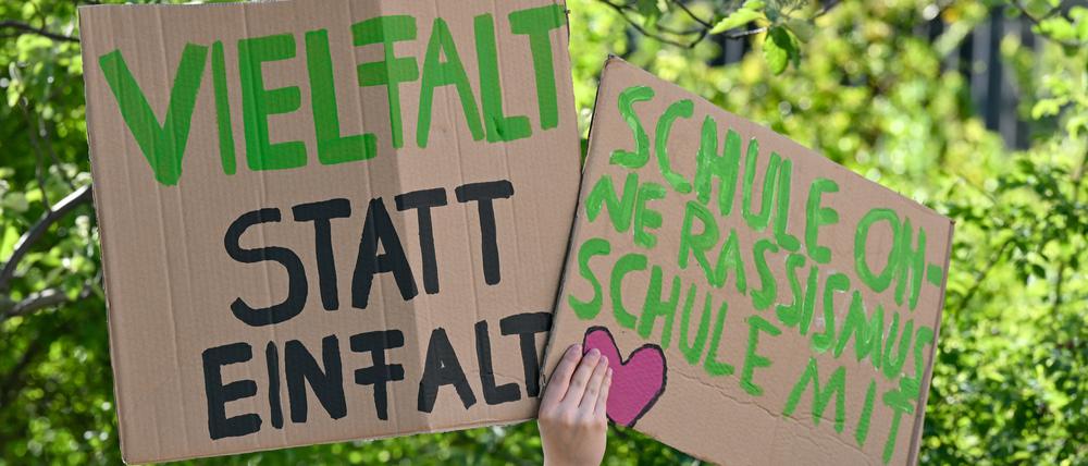 ARCHIV - 09.05.2023, Brandenburg, Cottbus: Teilnehmer der Demonstration «Vielfalt statt Einfalt - Schule ohne Diskriminierung» stehen mit Plakaten vor dem Schulamt in Cottbus. Organisiert wurde die Demonstration von Schülern, Eltern und Lehrern. Am Dienstag wollen Menschen erneut auf die Straße gehen. Kürzlich wurde bekannt, dass ein Lehrer zwei Schüler mit Migrationshintergrund angegriffen haben soll. (zu dpa: «Demo vor Cottbuser Schulamt nach Lehrer-Angriff auf zwei Schüler») Foto: Patrick Pleul/dpa +++ dpa-Bildfunk +++