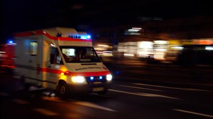 Rettungswagen des Deutschen Roten Kreuzes rast mit Blaulicht durch Berlin