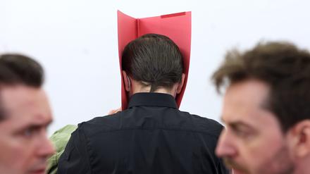 Der Angeklagte steht in einem Gerichtssaal des Landgerichtes in der Anklagebank zwischen seinen Anwälten Philip Müller (l) und Alexander Stevens. 